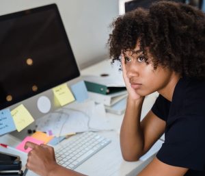 tired woman sitting by work desk