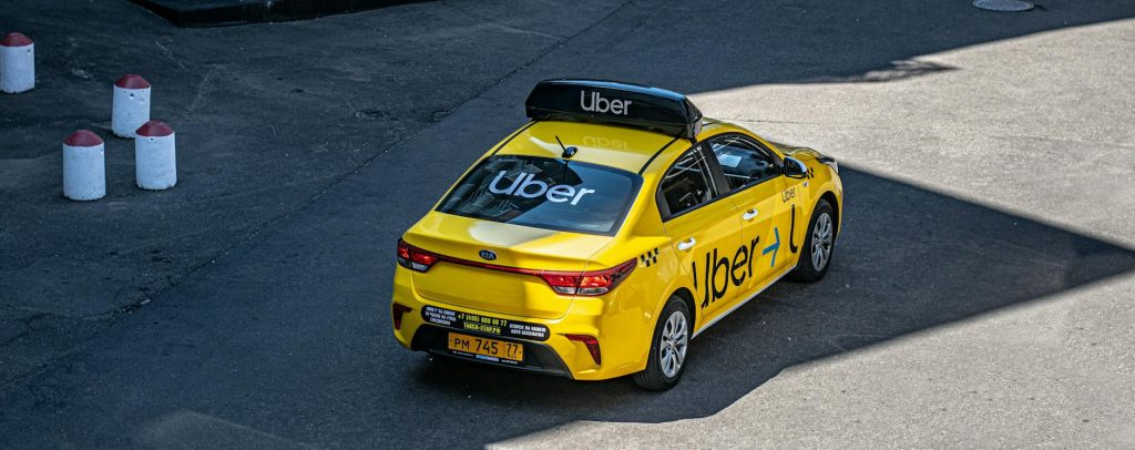 yellow uber taxi on urban street