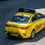 yellow uber taxi on urban street