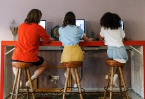 friends sitting on wooden bar stools