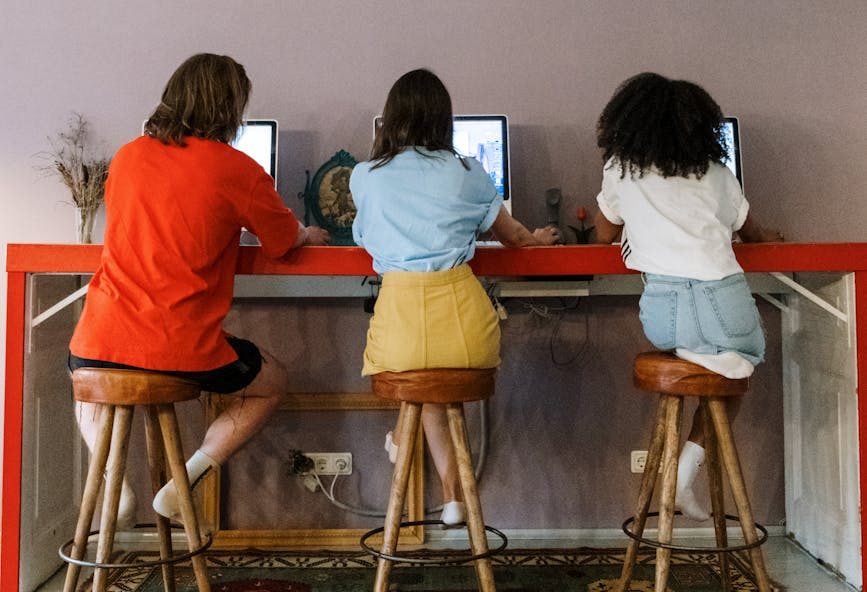 friends sitting on wooden bar stools
