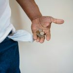 close up of man holding coins in hand